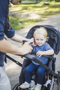 Happy man riding boy sitting in car