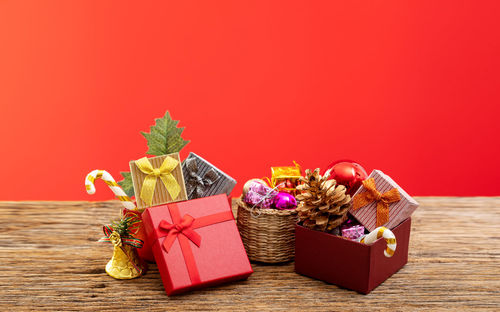 Various flowers in box on table against red background