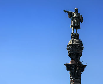 Low angle view of statue against clear blue sky