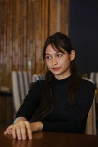 Portrait of young woman sitting on table