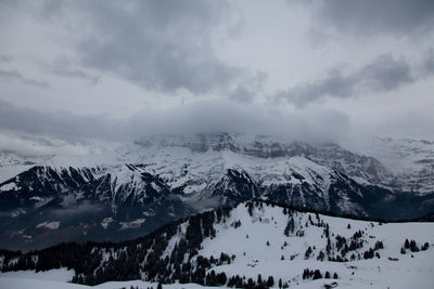 Scenic view of snow covered mountains against sky