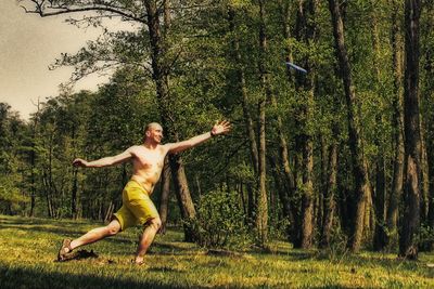 Shirtless man playing in park