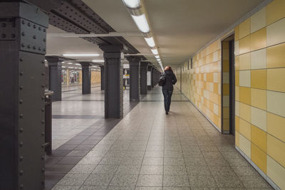 Rear view of woman walking in corridor