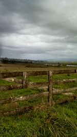 Scenic view of grassy field against cloudy sky