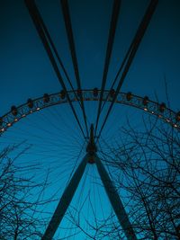 Low angle view of ferris wheel against clear blue sky