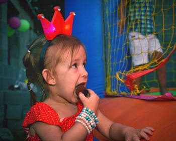 Close-up of cute girl eating chocolate at home