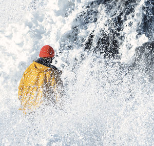 Rear view of person splashing water