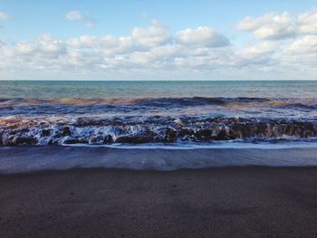 Scenic view of sea against cloudy sky