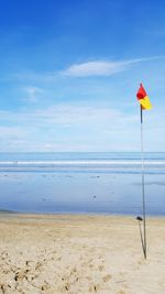 Scenic view of beach against cloudy sky