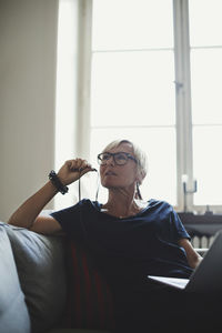 Mid adult man using mobile phone at home