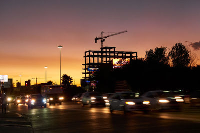 Cars on street in city at sunset