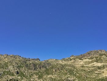 Low angle view of mountain against clear blue sky