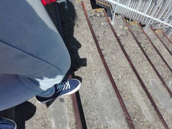 Low section of person standing on railroad tracks