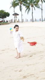 Happy girl playing with toys at beach