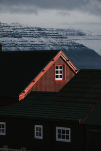 Wooden residential house in settlement in autumn on faroe islands on snowy mountains