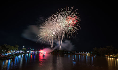 Firework display over river at night