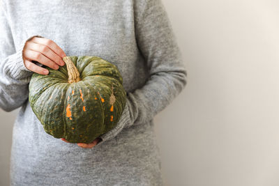 Midsection of woman holding pumpkin