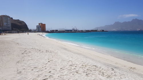 Scenic view of beach against clear blue sky