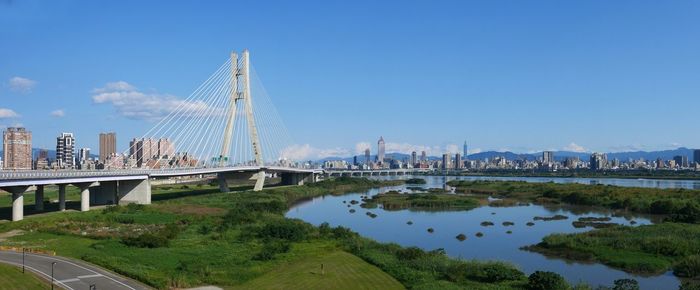 Bridge over city against blue sky
