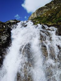 Scenic view of waterfall against sky