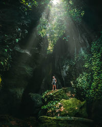 Woman standing on rock in forest