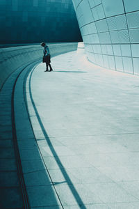 Young woman walking on street by building