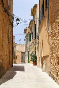 Alley amidst buildings on sunny day