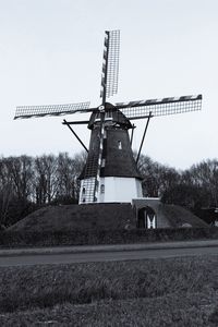 Traditional windmill on field against clear sky