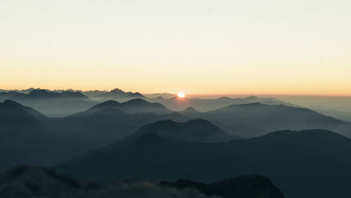 Scenic view of silhouette mountains against clear sky during sunset