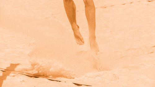 Low section of man standing on beach