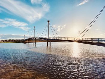 Bridge over calm sea against sky