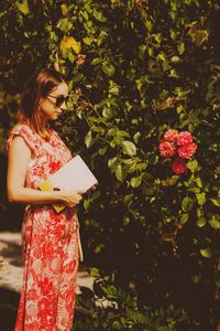 Woman standing by flowering plants