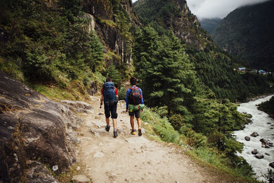 Rear view of friends with backpacks hiking at sagarmatha national park