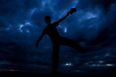 Low angle view of silhouette person against sky at night