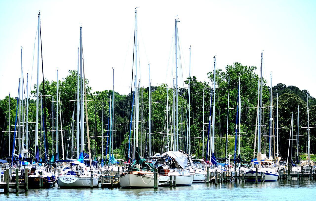 BOATS MOORED BY SEA AGAINST SKY