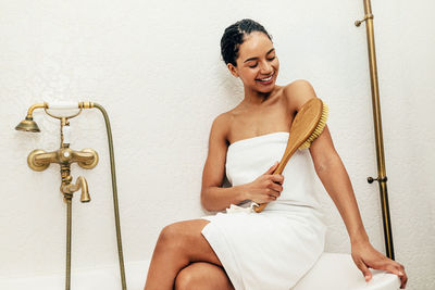 Woman brushing hand in bathroom at home