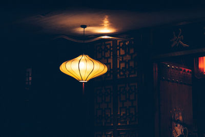 Low angle view of illuminated pendant lights hanging from ceiling