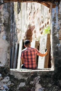 Rear view of man taking selfie in abandoned building