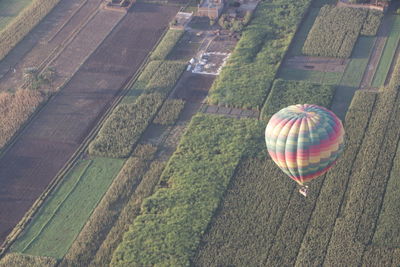High angle view of hot air balloon flying over field