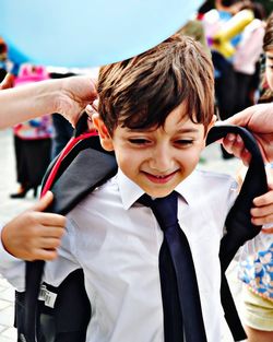 Close-up of schoolboy wearing backpack while standing outdoors
