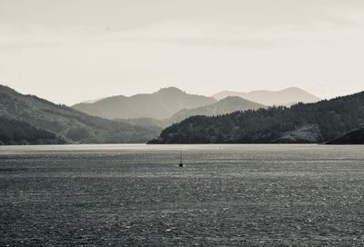 Scenic view of sea and mountains against sky