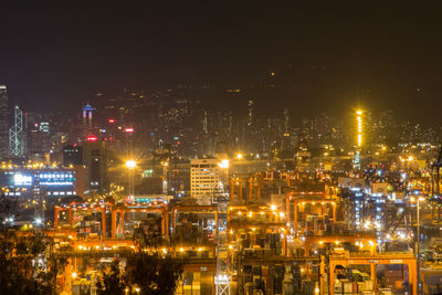 Illuminated cityscape against sky at night