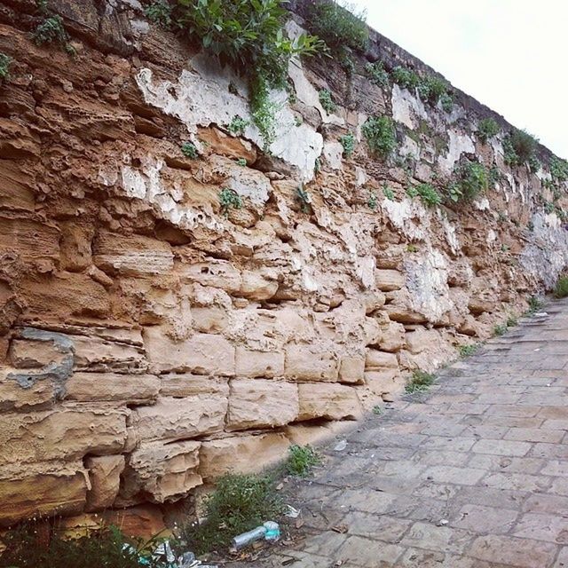 textured, rock - object, rock formation, stone wall, rough, wall - building feature, built structure, stone, rock, day, wall, weathered, outdoors, no people, nature, architecture, stone - object, sunlight, eroded, pattern