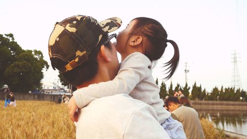 Couple kissing against clear sky