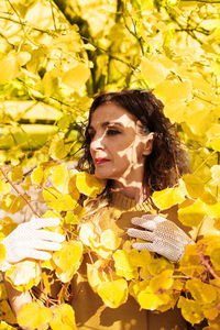Woman standing amidst autumn leaves
