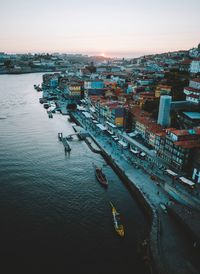 High angle view of river amidst buildings in city at sunset