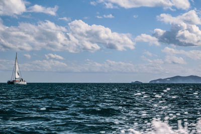 Sailboat sailing in sea against sky