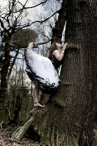 Die view of woman standing on tree