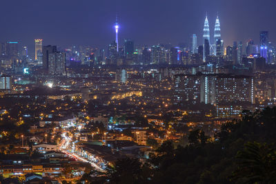 Illuminated cityscape against sky at night