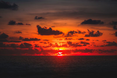 Scenic view of sea against dramatic sky during sunset